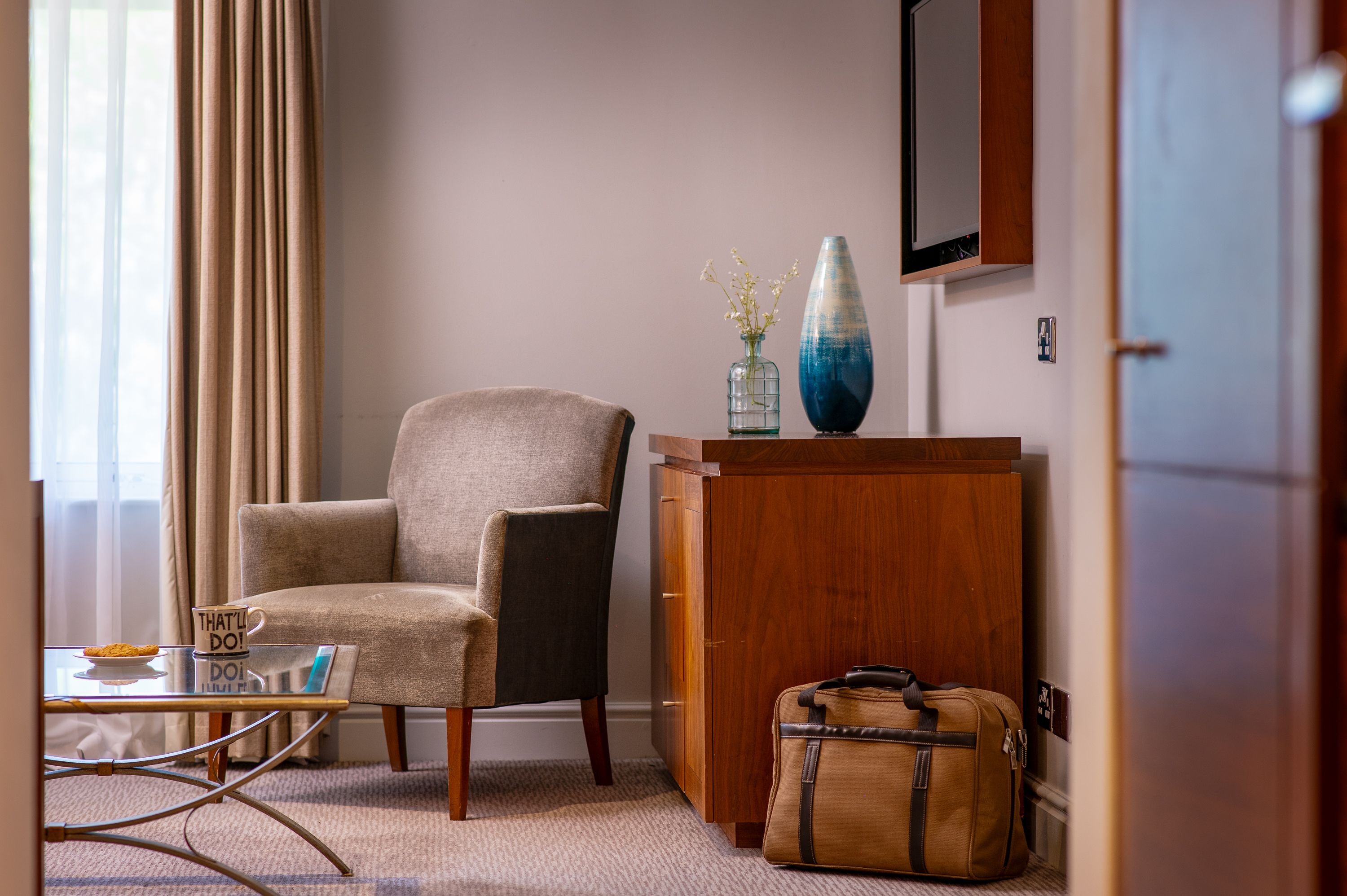 corner of room with chair, table and cup of tea