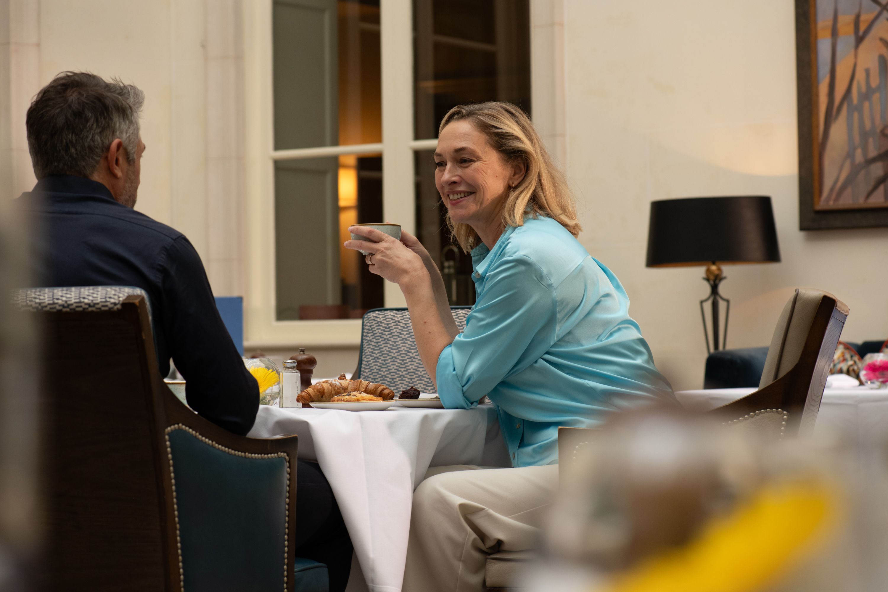 a lady drinking coffee in a restaurant