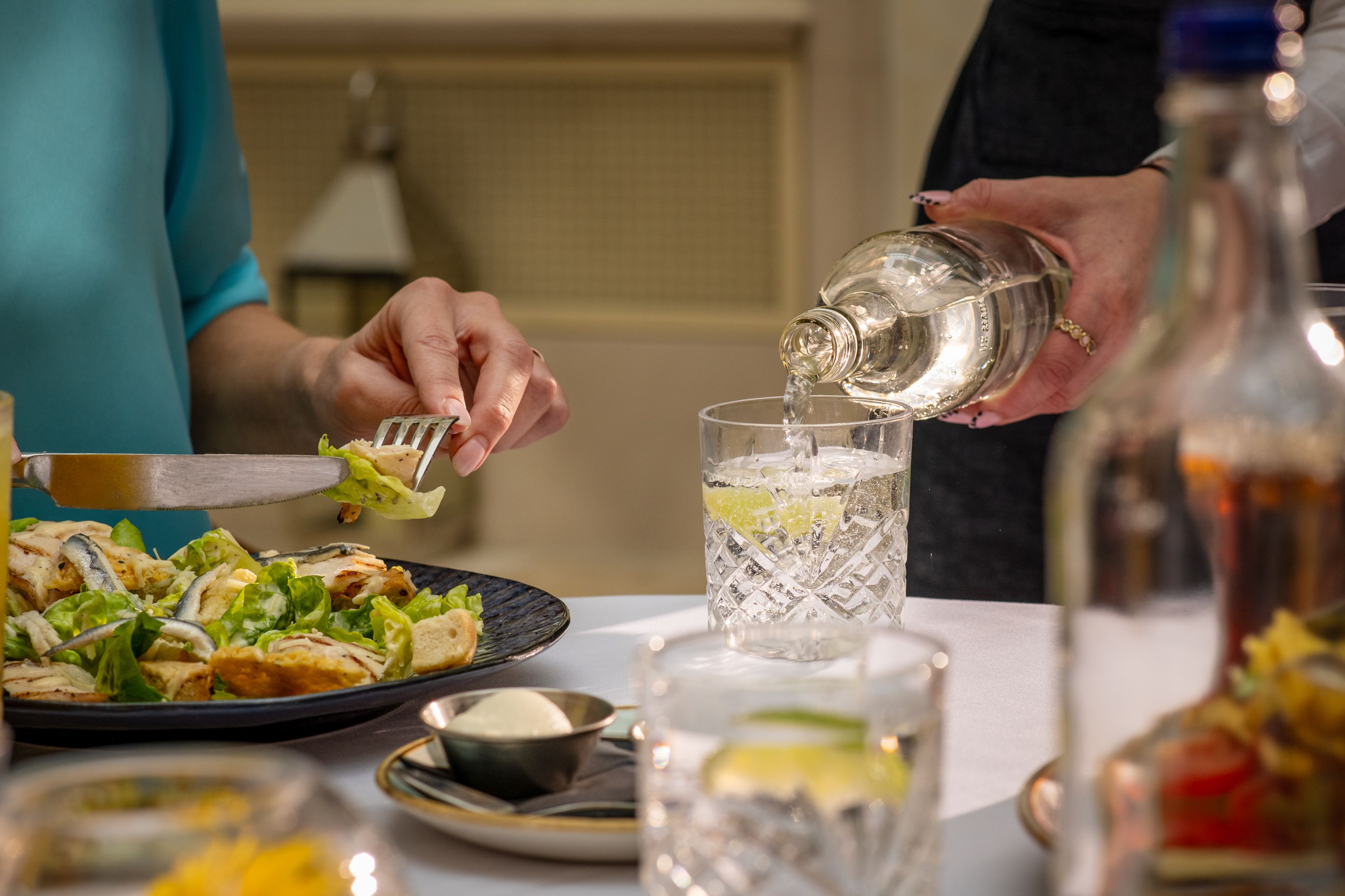 water being poured whilst person eats