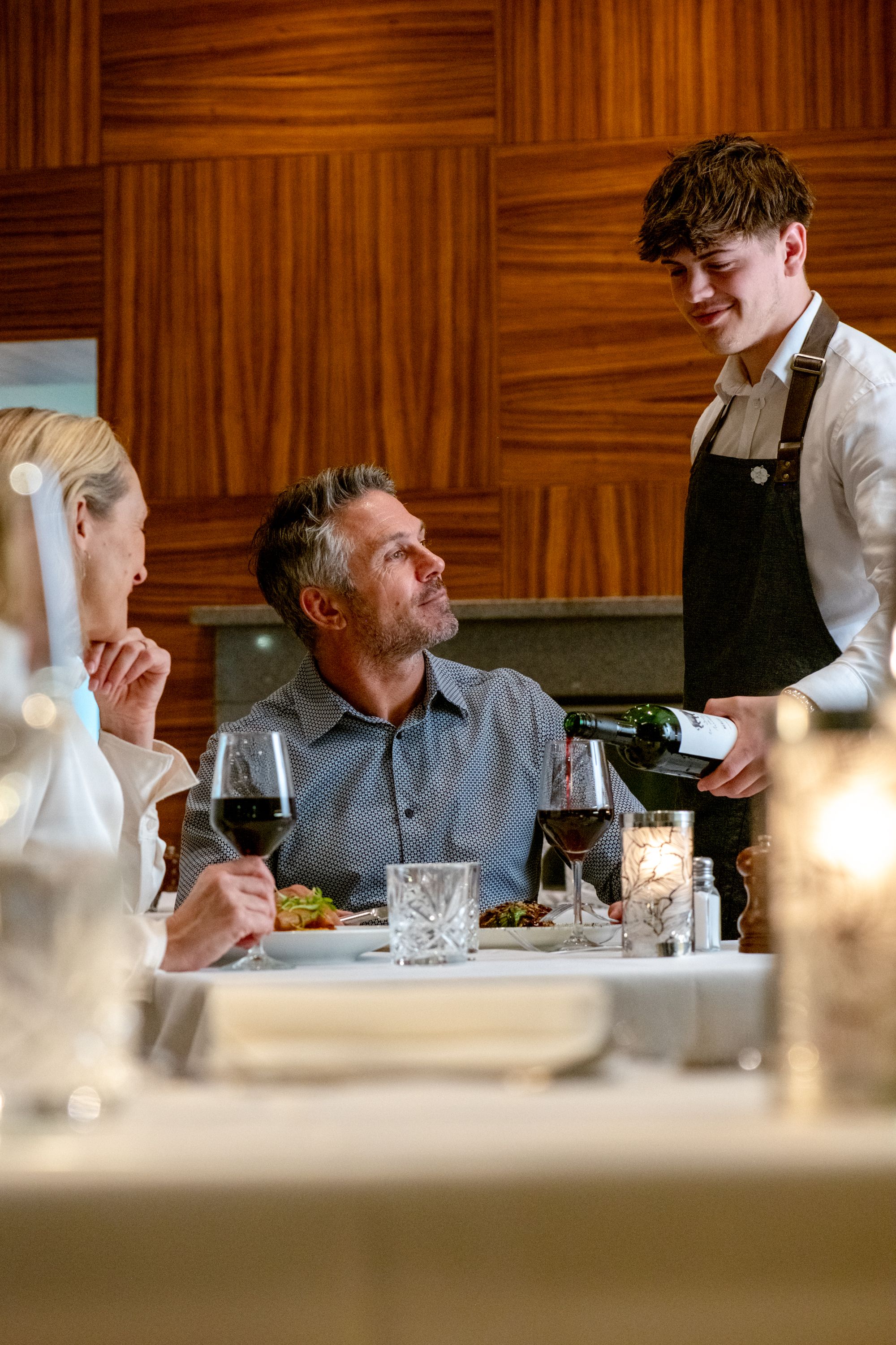 waiter pouring water for people eating